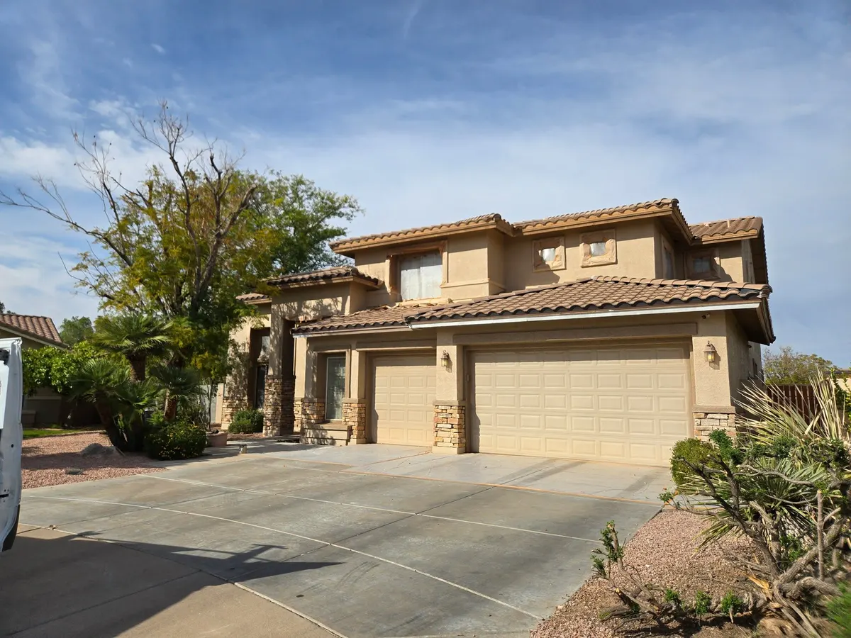 Stucco home with windows and lights masked before spray painting